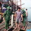 Border guards of Quang Binh province bring the saved fishermen to the mainland. (Source: VNA)