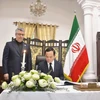 Deputy PM Tran Luu Quang writes in the condolence book at the Iranian Embassy in Hanoi on May 23. (Photo: qdnd.vn)