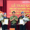 Deputy Minister of Public Security Sen. Lt. Gen. Luong Tam Quang (centre) presents the State President's decisions to the two officers on May 29. (Photo: VNA)