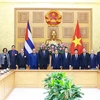 PM Pham Minh Chinh (8th from right), President of the National Assembly of People's Power of Cuba Esteban Lazo Hernandez (9th from right), and officials of the two countries pose for a group photo at the meeting in Hanoi on July 24. (Photo: VNA)
