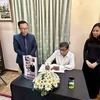 G. Weerasinghe, General Secretary of the Communist Party of Sri Lanka, writes the book of condolences at the respect-paying ceremony held by the Vietnamese Embassy in Sri Lanka on July 25. (Photo: VNA)