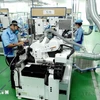 Workers produce electronic components at the factory of the Japanese-invested INOAC Co. Ltd in the Quang Minh Industrial Park of Hanoi. (Photo: VNA)