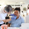 A doctor gives a dental check-up to a child at the September 7 event in the Czech Republic. (Photo: VNA)