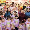 The spouse of Party General Secretary and State President of Vietnam To Lam, Ngo Phuong Ly (left, in blue dress), and the spouse of Party General Secretary and President of Laos Thongloun Sisoulith, Naly Sisoulith (right, in brown dress) join children of Birla Children's Village Hanoi in a celebration of the Mid-Autumn Festival on September 10. (Photo: VNA)