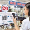 A woman pays for medical examination via QR code at a hospital in Hanoi. (Photo: nhandan.vn)