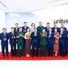 Prime Minister Pham Minh Chinh (front, centre) and executives and staff members of Star Telecom (Unitel) pose for a group photo on October 8. (Photo: VNA)