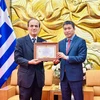 President of the Vietnam Union of Friendship Organisations Phan Anh Son (right) presents the honour to Greek Ambassador to Vietnam Georgios Stilianopoulos at the ceremony in Hanoi on October 15. (Photo: VNA) 