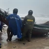 Authorities assist fishermen to move boats onto the shore before Storm Trami hit the mainland in Thua Thien - Hue province. (Photo: VNA)