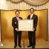 Hoang Binh Quan (left), former member of the Party Central Committee and former Chairman of its Commission for External Relations, receives the “Order of the Rising Sun, Gold and Silver Star” from Japanese Ambassador Ito Naoki on December 15. (Source: VNA)