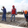 Des travailleurs sur le chantier de construction du pont de Da Rang dans le cadre du projet de l'autoroute Nord-Sud. Photo : VNA