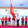 Le ministre de la Culture, des Sports et du Tourisme, Nguyen Van Hung (droite), remet le drapeau symbolisant la détermination à concourir au chef de la délégation vietnamienne aux JO de Paris 2024, Dang Ha Viet. Photo: VNA