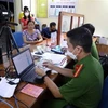 La police de la commune de Yen Thuong, district de Gia Lam, à Hanoï, aide les habitants à effectuer les procédures d'enregistrement de la carte d'identité à puce. Photo: VNA