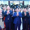 Le Premier ministre Pham Minh Chinh, le professeur Klaus Schwab, et des jeunes vietnamiens. Photo: VNA