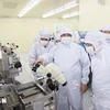 El primer ministro Pham Minh Chinh visita la línea de producción de chips semiconductores de la empresa Hana Micro Vina (Foto: VNA)