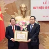 El presidente parlamentario Tran Thanh Man (derecha) entrega la insignia por 40 años de membresía del PCV a Nguyen Duc Hai, miembro del Comité Central del Partido y miembro del Comité de asuntos partidistas de la AN y vicepresidente del Parlamento. (Fuente:VNA)