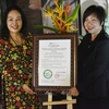 Ngô Kim Trang, subjefa del Instituto de Investigación Aplicada e Innovación en Empresas, entrega el certificado de estación de cero emisiones netas al complejo Suoi Rao Ecolodge. (Fuente:VNA)