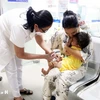 Personal médico inyecta vacuna a un niño. (Foto: Vietnam+)