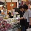 Des consommateurs japonais au stand des fruits vietnamiens. Photo: VNA