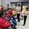 Des Vietnamiens en France offrent des cadeaux aux sportifs handicapés vietnamiens. Photo: VNA