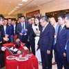 Le président du Comité populaire de Hanoï, Tran Sy Thanh, et d'autres délégués visitent la zone d'exposition des produits et services au service de la construction de villes intelligentes. Photo: VNA