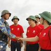 Des représentants du groupe EVN et un soldat sur l'île de Song Tu Tay. Photo : VNA