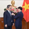 Le ministre vietnamien des Affaires étrangères Bui Thanh Son (droite) remet le 8 mai à Hanoï l’Insigne "Pour la cause de la diplomatie vietnamienne" à l'ambassadeur du Japon au Vietnam, Yamada Takio. Photo : VNA