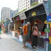 Les touristes étrangers visitent un stand des produits de Hanoï. Photo : Quang Châu/CVN