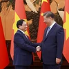 El primer ministro de Vietnam, Pham Minh Chinh, y el secretario general del Partido Comunista y el presidente de China, Xi Jinping. (Foto: VNA)