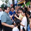 El primer ministro Pham Minh Chinh con los residentes del proyecto de vivienda social Thong Nhat. (Foto: VNA)