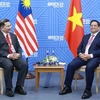 El primer ministro de Vietnam, Pham Minh Chinh, sostiene un encuentro con el ministro de Economía de Malasia, Rafizi Ramli. (Foto: VNA)