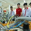 Présentation de modèles d'automatisation aux étudiants de la classe d'électronique industrielle K13 du Collège professionnel de haute technologie de Hanoi. Photo : Hoang Hieu/VNA