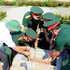 La cérémonie d’inhumation de 11 restes de martyrs volontaires vietnamiens tombés au Laos. Photo : VNA