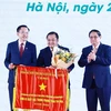 Le Premier ministre Pham Minh Chinh offre le drapeau d'émulation au Groupe chimique du Vietnam (Vinachem). Photo : VNA