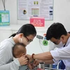 Un petit enfant s'est fait vacciner contre la rougeole au poste médical du quartier Phuoc Long A (ville de Thu Duc). Photo : VNA