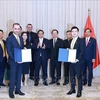 Le Premier ministre Pham Minh Chinh (centre) assiste à la remise du protocole d'accord sur la recherche d'investissement dans le projet de complexe sportif et de centre commercial à Dong Anh entre T&T du Vietnam et JTA International Holding. Photo : VNA