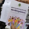 An official gives a senator candidate handbook and an application form to a woman applying for the senate election at Khon Kaen's registration office in Muang district on May 10 (Photo: Bangkokpost.com)