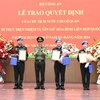 Authorised by the President, Minister of Public Security Sen. Lieut. Gen. Luong Tam Quang presents the decisions to the three officers (Photo: VNA)