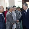 State President To Lam (R) meets Vietnamese Embassy staff and representatives of the Vietnamese community in Laos (Photo: VNA)