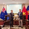 Ambassador Pham Hung Tam (R) hands over 12,700 AUD (8,700 USD) to the delegation to help victims of Typhoon Yagi (Photo: VNA)