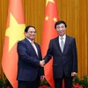 Prime Minister Pham Minh Chinh (L) and Wang Huning, a member of the Standing Committee of the Communist Party of China (CPC) Central Committee’s Political Bureau and Chairman of the Chinese People's Political Consultative Conference (CPPCC) National Committee, at their meeting in Beijing on June 26. (Photo: VNA)