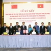 Representatives from Quang Ninh and Guangxi Zhuang Autonomous Region witness the signing of a tourism development cooperation agreement between the two localities' enterprises. (Photo: VNA)