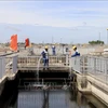 Workers spray water to clean the filtration tank and remove debris at the Binh Hung wastewater treatment plant in HCM City. (Photo: VNA)