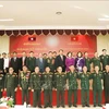 Participants pose for a group photo at the October 24 meeting marking the 75th anniversary of the traditional day of Vietnam’s volunteer soldiers and experts in Laos. (Photo: VNA)