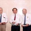 Nguyen Van Nen, Politburo member and Secretary of the Ho Chi Minh City Party Committee, presents the HCM City Badge to Olivier Parriaux and Bernard Bachelard at the meeting. (Photo: VNA)