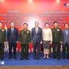 Participating Vietnamese and Lao delegates pose for a group photo at the ceremony. (Source: VNA)