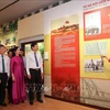 A los visitantes se les informa sobre las fotografías expuestas en la exposición. (Foto: VNA)