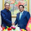 El primer ministro Pham Minh Chinh (derecha) y su homólogo malasio Anwar Ibrahim en su reunión en Vientiane el 10 de octubre. (Foto: VNA)