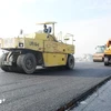 Making an asphalt road section of a project on North-South expressway’s eastern wing (Photo: VietnamPlus)