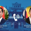 Les deux ministres des AE du Vietnam (gauche) et de la Thaïlande s’entretiennent au téléphone. Photo: VNA