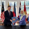L’ambassadeur du Vietnam en République tchèque, Duong Hoai Nam, reçoit la présidence tournante du Comité de l'ASEAN en République tchèque (ACP), transférée par l’ambassadrice de Malaisie, Suzilah Mohd Sidek. Photo: VNA